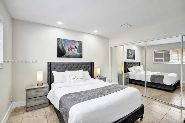 a bedroom with a bed and a lamp on dresser