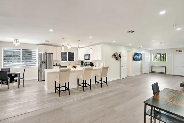 a view of kitchen with dining table chairs and refrigerator