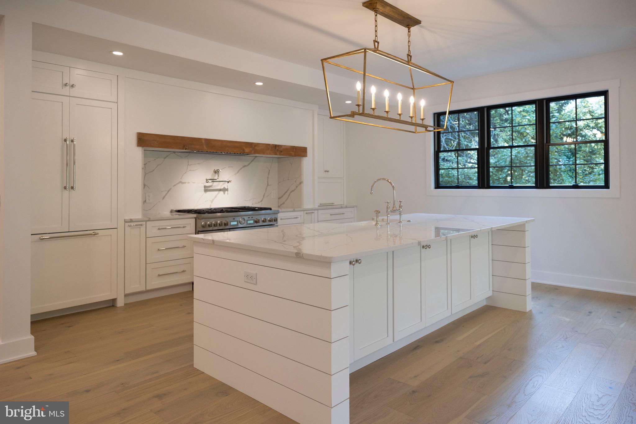 a kitchen with white cabinets and chandelier