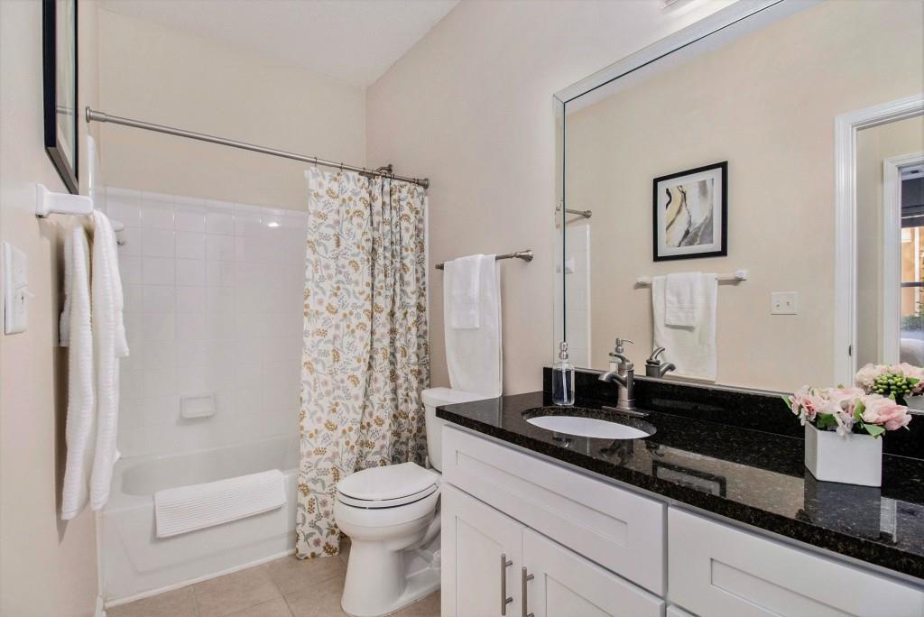10 Perimeter Summit Boulevard, Unit 2112 Atlanta, GA 30319 - Photo 25 of 40 a bathroom with a granite countertop sink a toilet a mirror a bathtub and shower