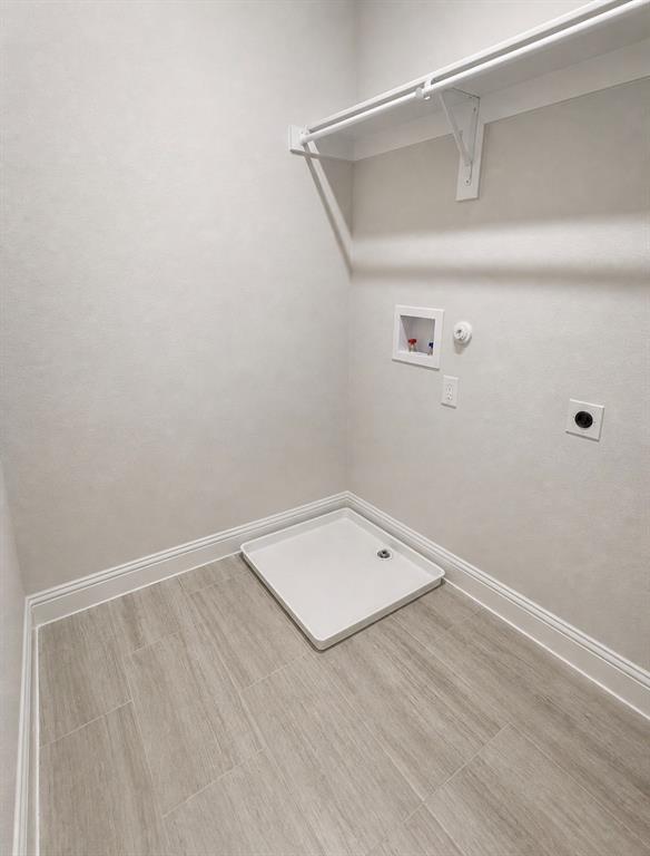 7849 Sunset Boulevard Rowlett, TX 75088 - Photo 11 of 13 Laundry area featuring light wood-finish tile flooring, white baseboards, and neutral wall paint
