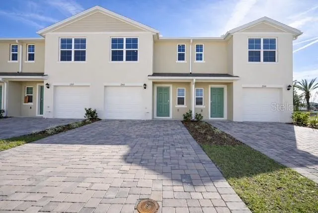 a front view of a house with a yard and potted plants