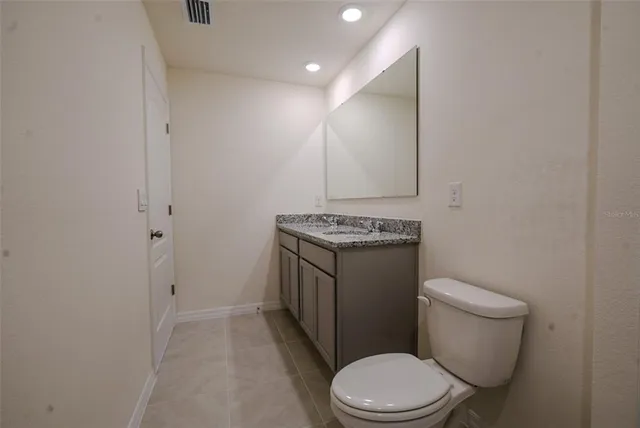a utility room with granite countertop cabinets and sink