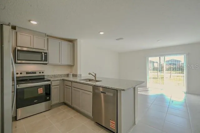 a kitchen with stainless steel appliances granite countertop a stove a sink and a microwave