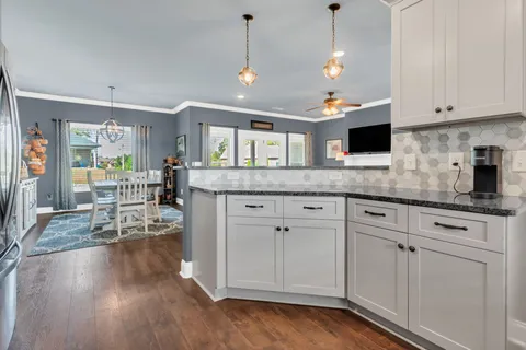 a kitchen with stainless steel appliances granite countertop a sink a stove and a wooden floors