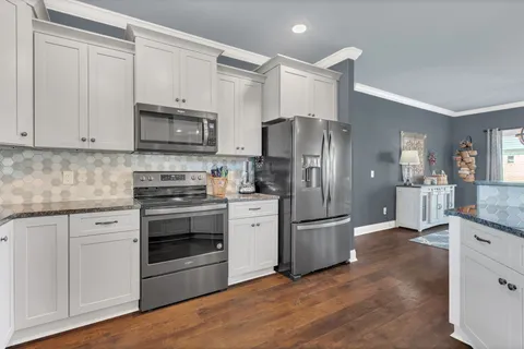 a kitchen with stainless steel appliances granite countertop a refrigerator stove and sink