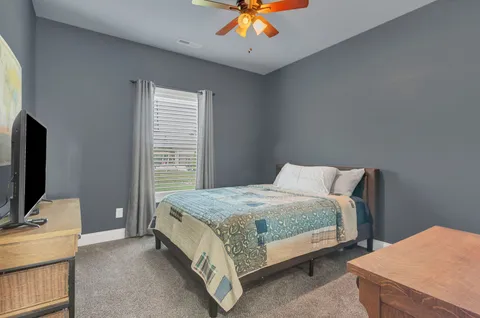 a spacious bedroom with a bed and a chandelier