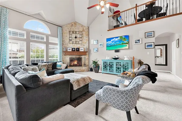 a living room with furniture fireplace and a large window