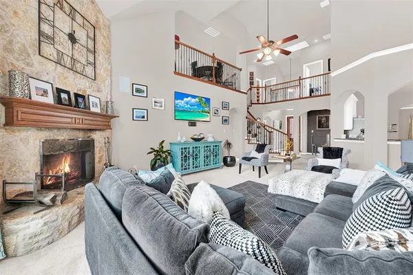 a living room with furniture a fireplace and a chandelier