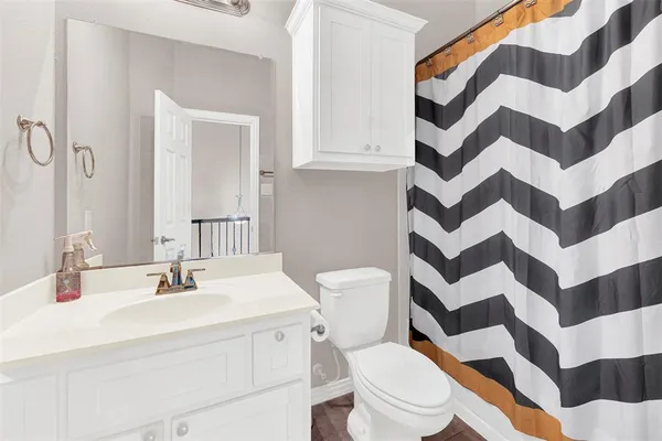 a bathroom with a sink a toilet a shower curtain