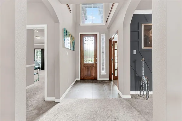 wooden floor with a chandelier and a glass door