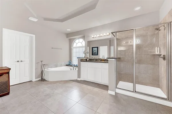 a bathroom with a tub mirror and shower