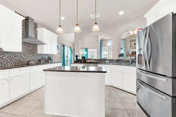 a kitchen with stainless steel appliances granite countertop a refrigerator a oven a sink and a refrigerator