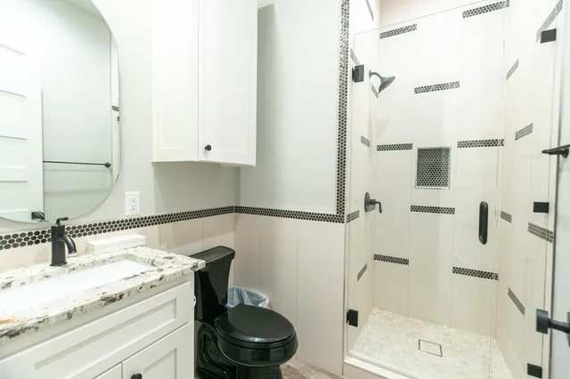 a bathroom with a granite countertop sink toilet and shower
