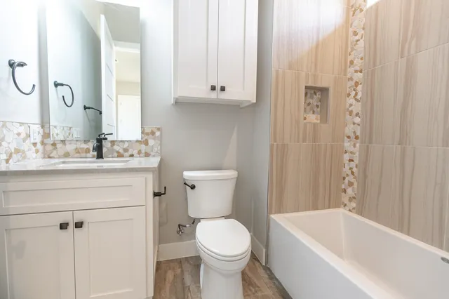 a bathroom with a sink a toilet and shower