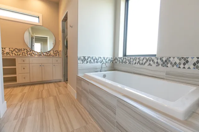a bathroom with a bathtub sink and mirror