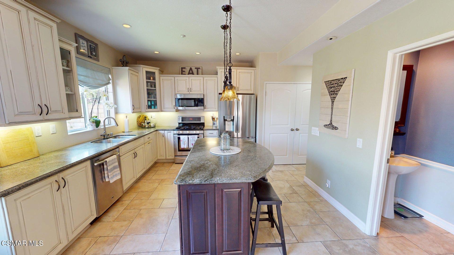 293 Springmist Lane Simi Valley, CA 93065 - Photo 14 of 50 a large kitchen with stainless steel appliances granite countertop a lot of counter space and wooden floors