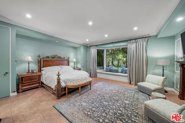 a bedroom with a bed and large window