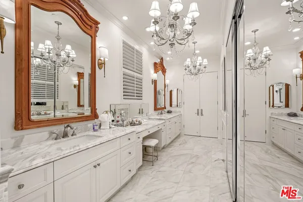a spacious bathroom with double vanity a mirror a double vanity and a shower