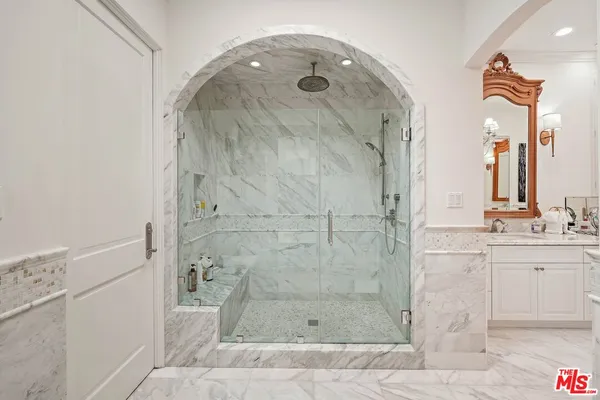 a bathroom with a granite countertop shower sink and mirror
