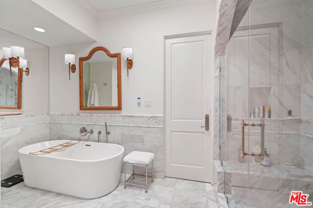 717 North Rodeo Drive Beverly Hills, CA 90210 - Photo 20 of 38 a bathroom with a tub sink and mirror