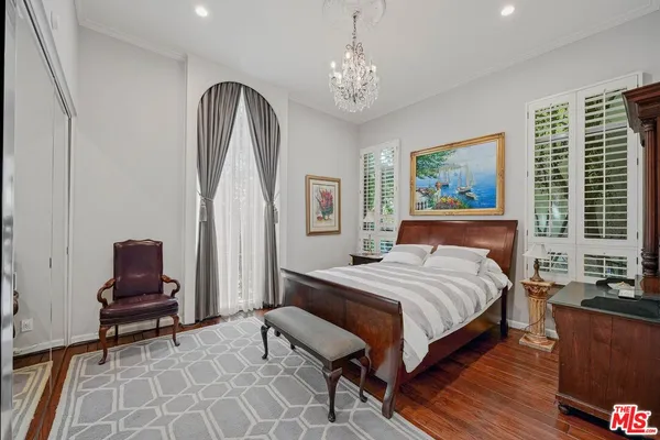 a bedroom with a bed and a chandelier