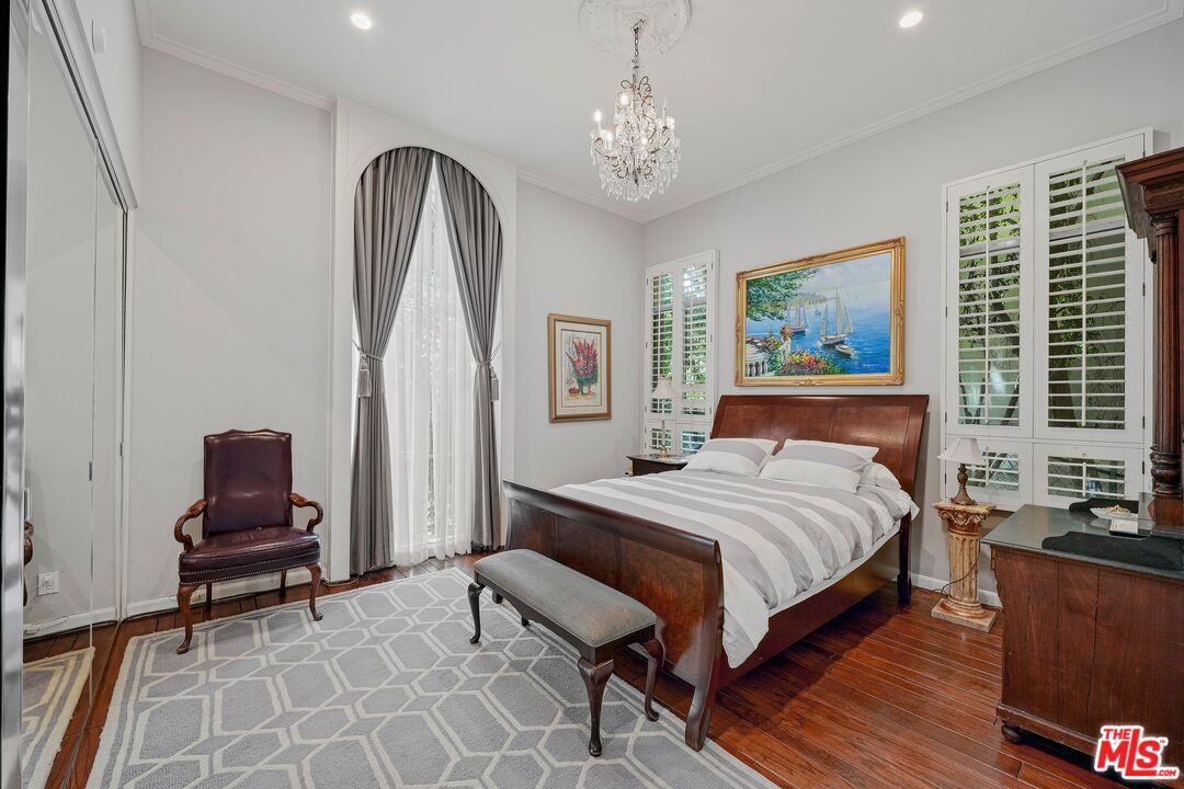 717 North Rodeo Drive Beverly Hills, CA 90210 - Photo 21 of 38 a bedroom with a bed and a chandelier