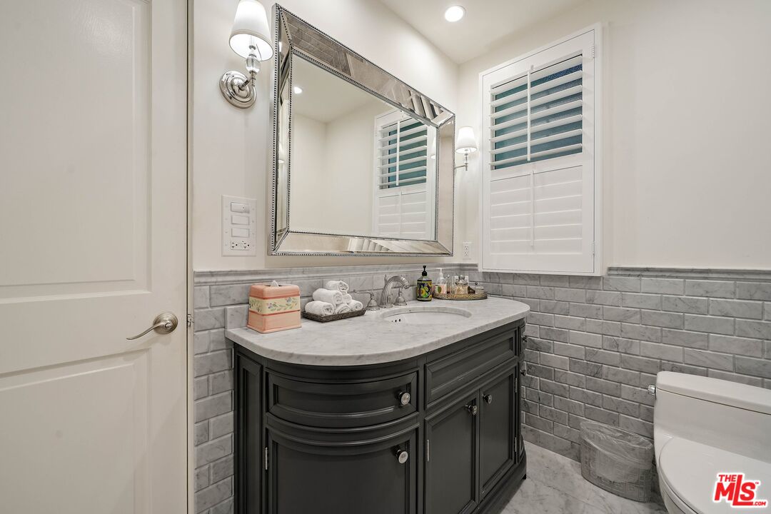 717 North Rodeo Drive Beverly Hills, CA 90210 - Photo 22 of 38 a bathroom with a sink and a mirror