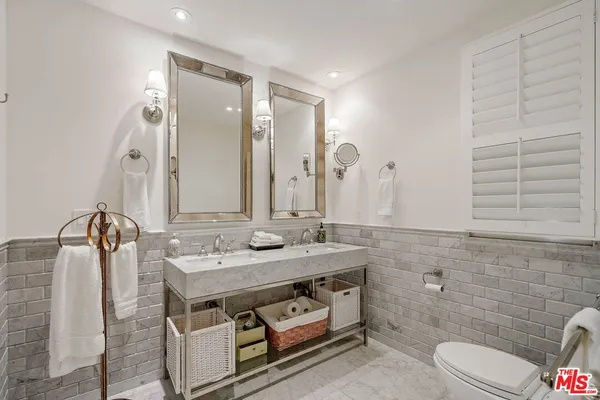 a bathroom with a granite countertop sink a toilet and mirror