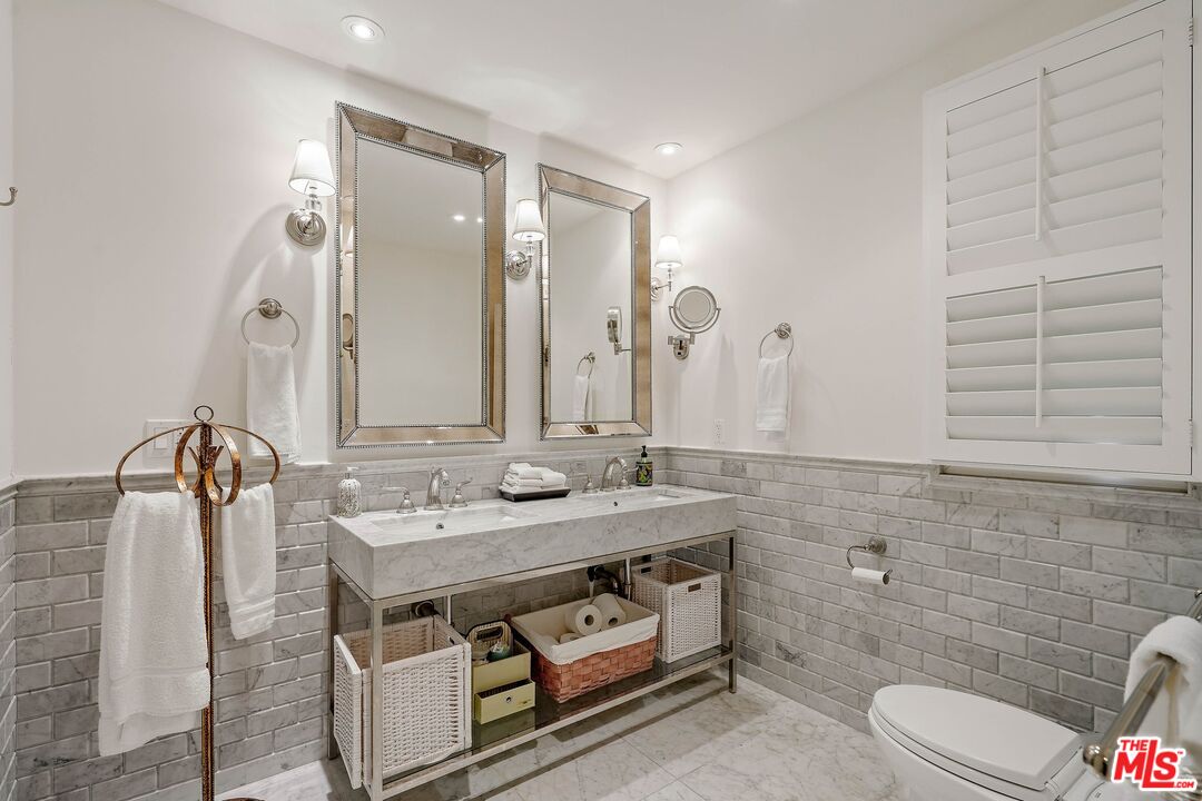 717 North Rodeo Drive Beverly Hills, CA 90210 - Photo 26 of 38 a bathroom with a granite countertop sink a toilet and mirror
