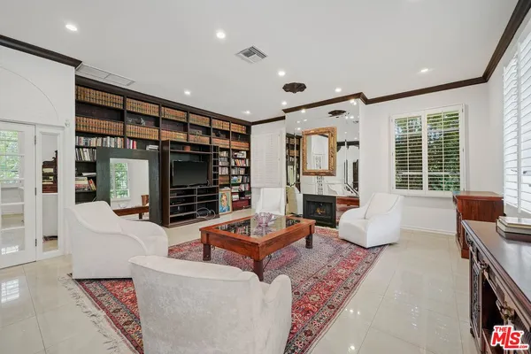 a living room with fireplace furniture and a large window