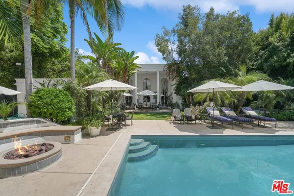 a view of a house with backyard and sitting area