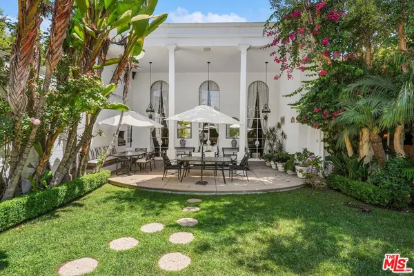 a view of house with backyard and outdoor seating