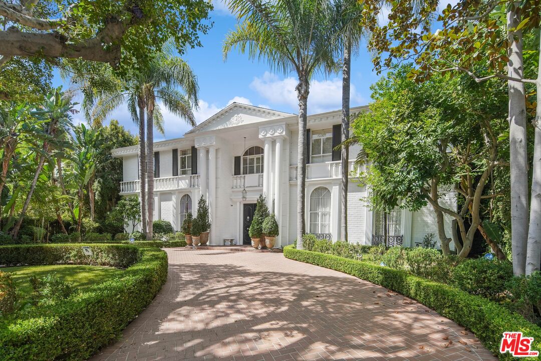 717 North Rodeo Drive Beverly Hills, CA 90210 - Photo 38 of 38 a front view of a house with a garden and yard