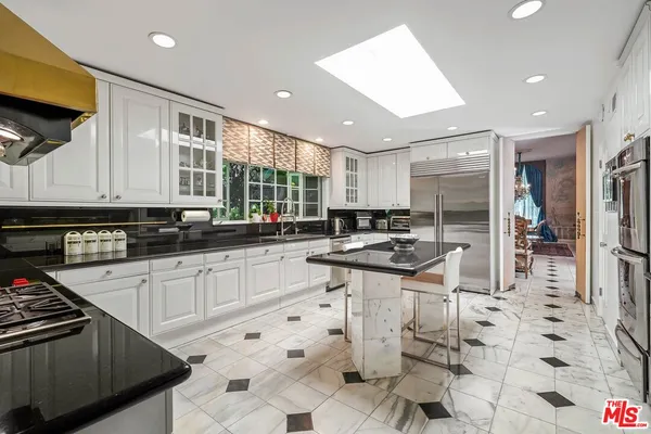 a kitchen with stainless steel appliances kitchen island granite countertop a sink and cabinets