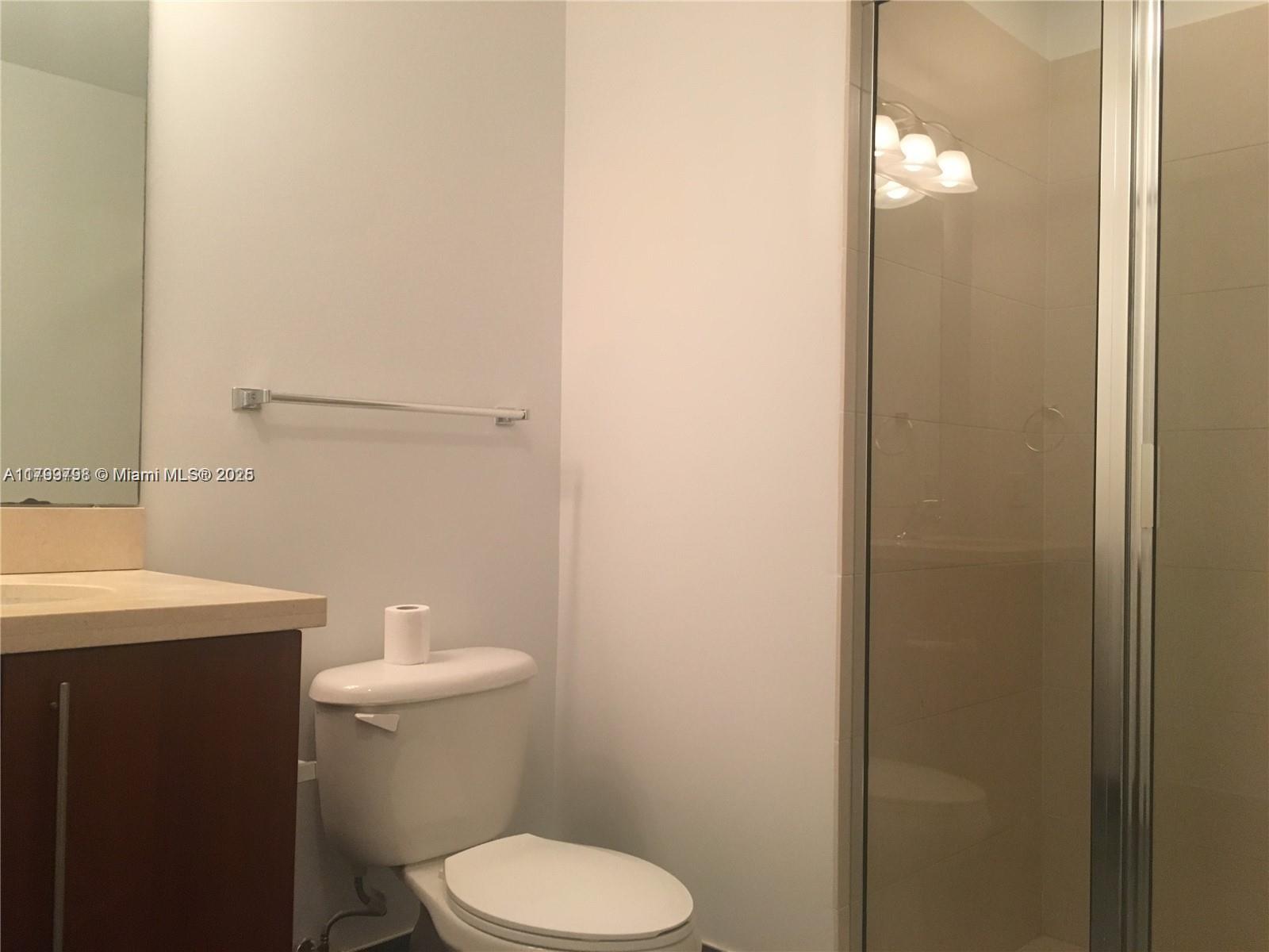 1111 Southwest 1st Avenue, Unit 2223N Miami, FL 33130 - Photo 12 of 23 a white toilet sitting next to a bathroom sink