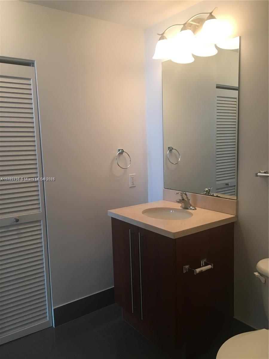 1111 Southwest 1st Avenue, Unit 2223N Miami, FL 33130 - Photo 13 of 23 a bathroom with a sink and mirror