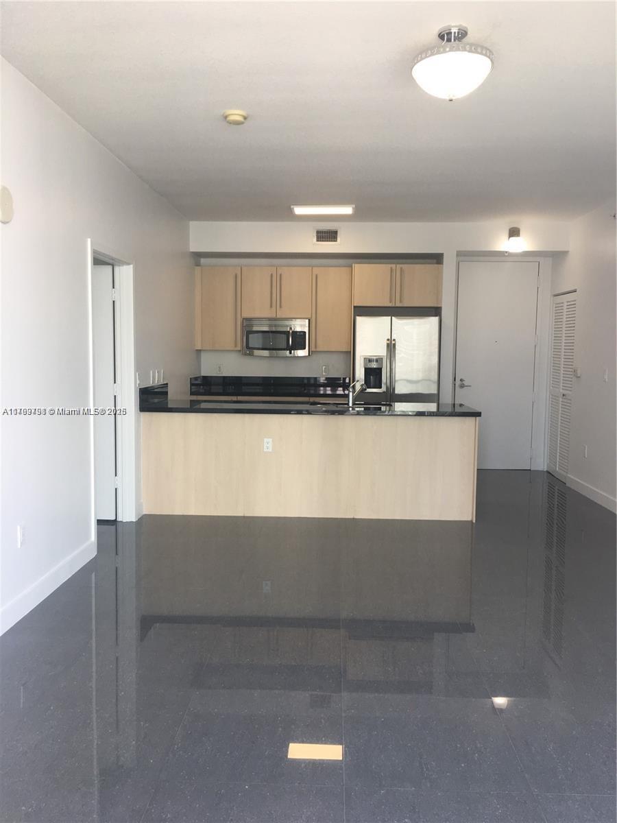 1111 Southwest 1st Avenue, Unit 2223N Miami, FL 33130 - Photo 5 of 23 a kitchen with stainless steel appliances granite countertop a sink and a stove