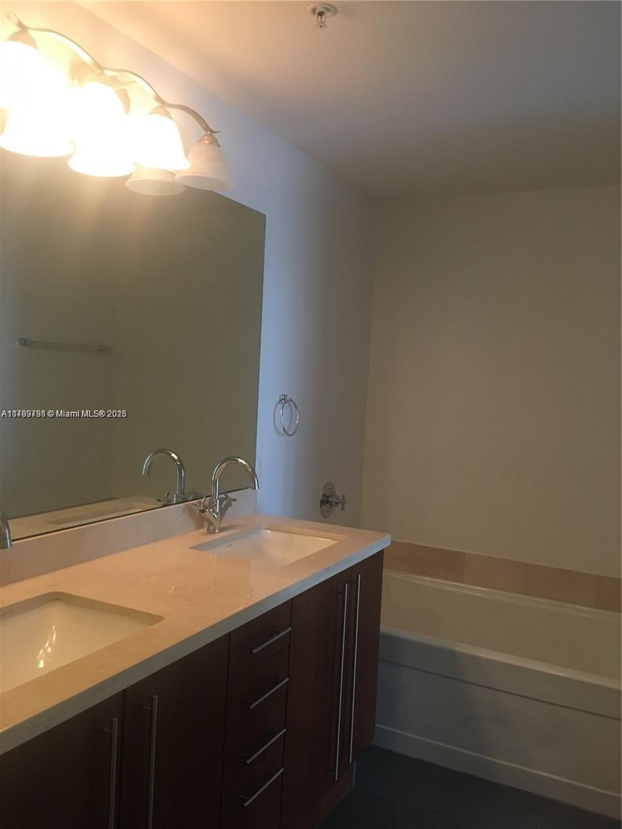 1111 Southwest 1st Avenue, Unit 2223N Miami, FL 33130 - Photo 10 of 23 a bathroom with a sink and a mirror