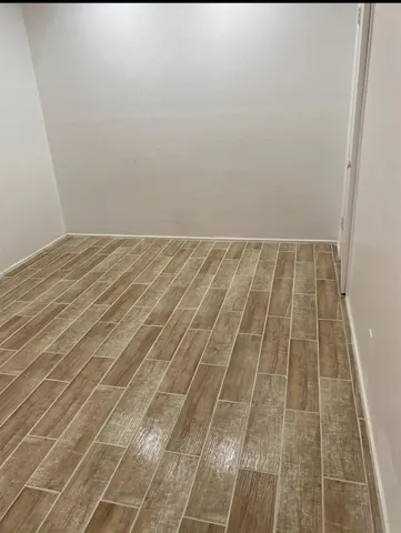 a view of a room with wooden floor