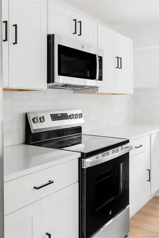 a kitchen with microwave stove and cabinets