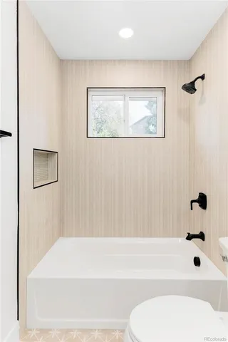 a bathroom with a toilet and a bathtub