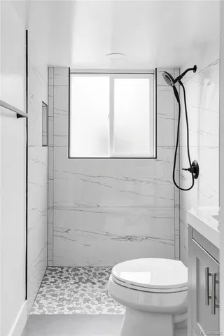 a bathroom with a toilet and a shower