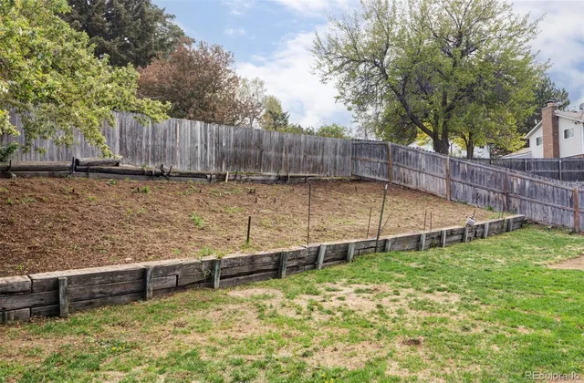 a view of a yard with wooden fence