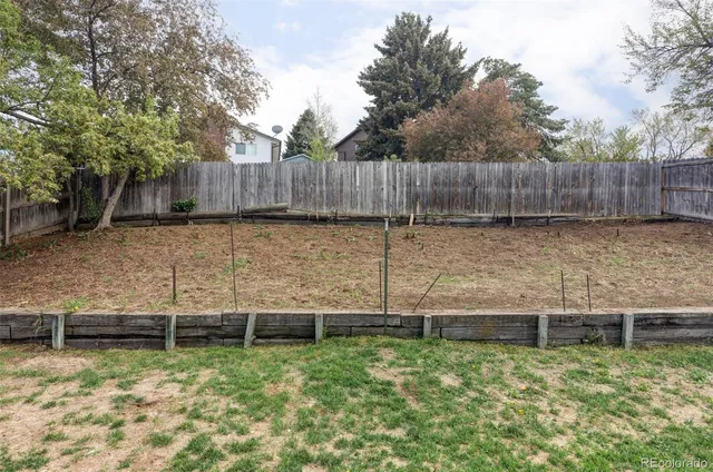 a view of a backyard with wooden fence