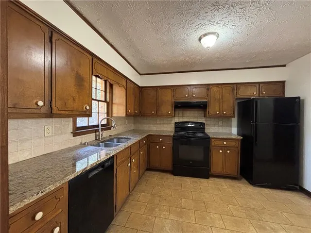 a large kitchen with granite countertop stainless steel appliances and a sink