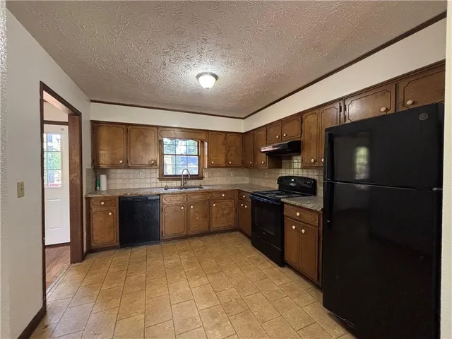 a large kitchen with a large counter top refrigerator and stove