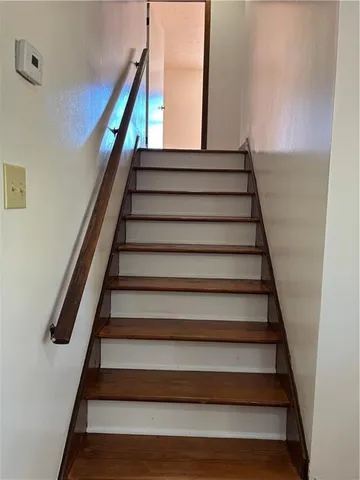 an empty room with wooden floor chandelier fan and windows