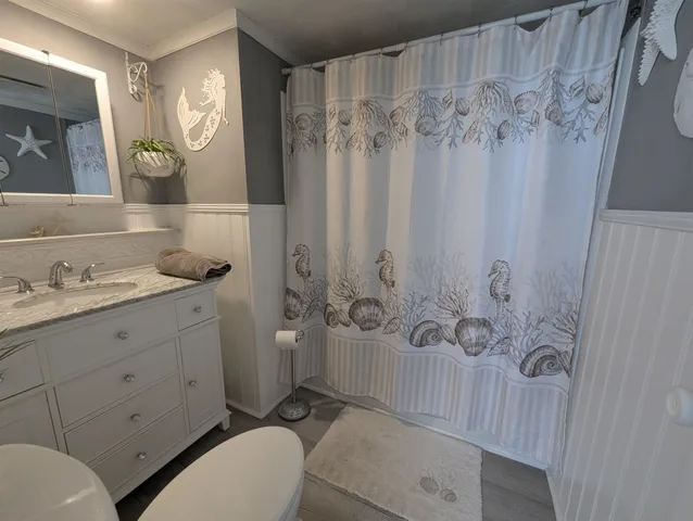 a bathroom with a granite countertop sink toilet a mirror a vanity and shower