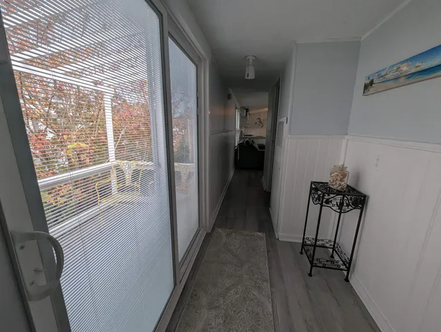 a view of hallway with a window and wooden floor